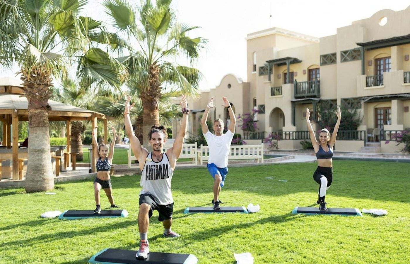 Yoga-Kurs im Freien am Three Corners Rihana Resort mit Teilnehmern und Palmen im Hintergrund.