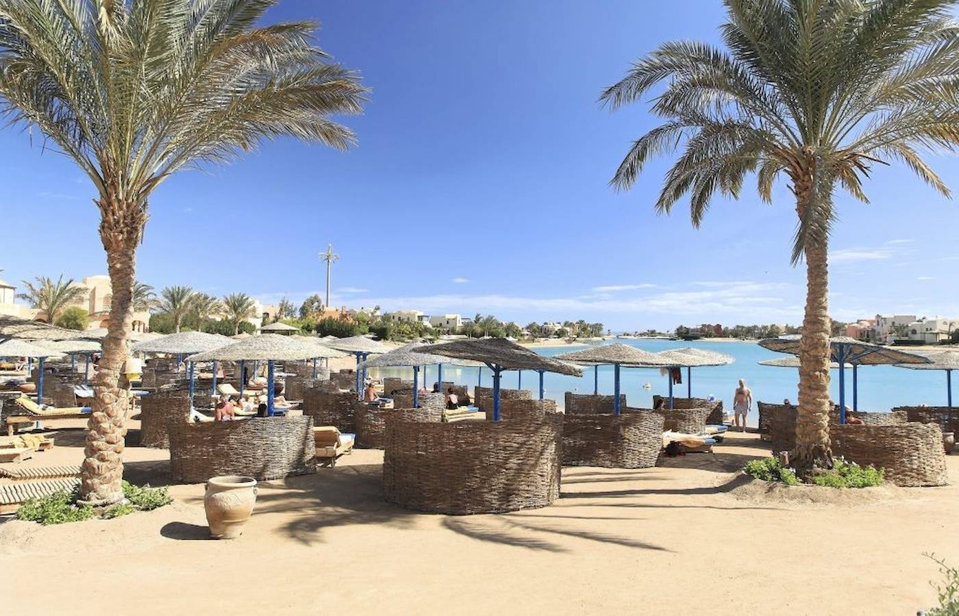 Drei-Ecken-Rihana-Resort-Strand mit Sonnenschirmen und Palmen