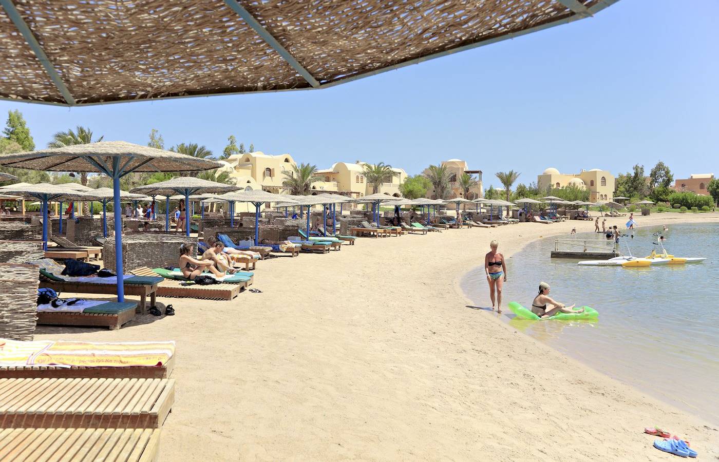 Strandszene mit Sonnenschirmen und Liegen im Three Corners Rihana Resort.