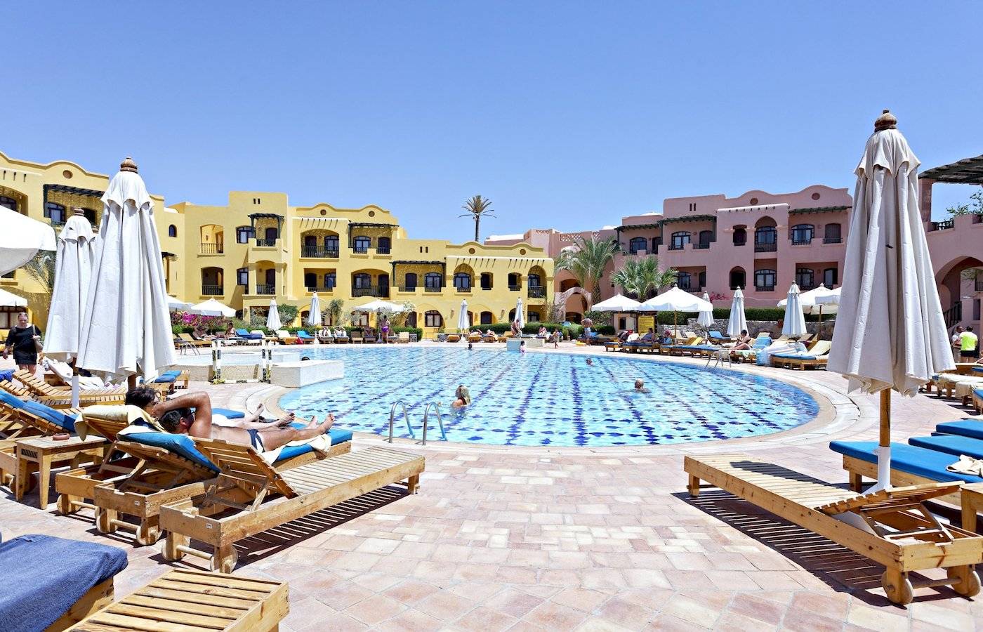 Swimmingpool im Three Corners Rihana Resort mit Sonnenliegen und Sonnenschirmen.