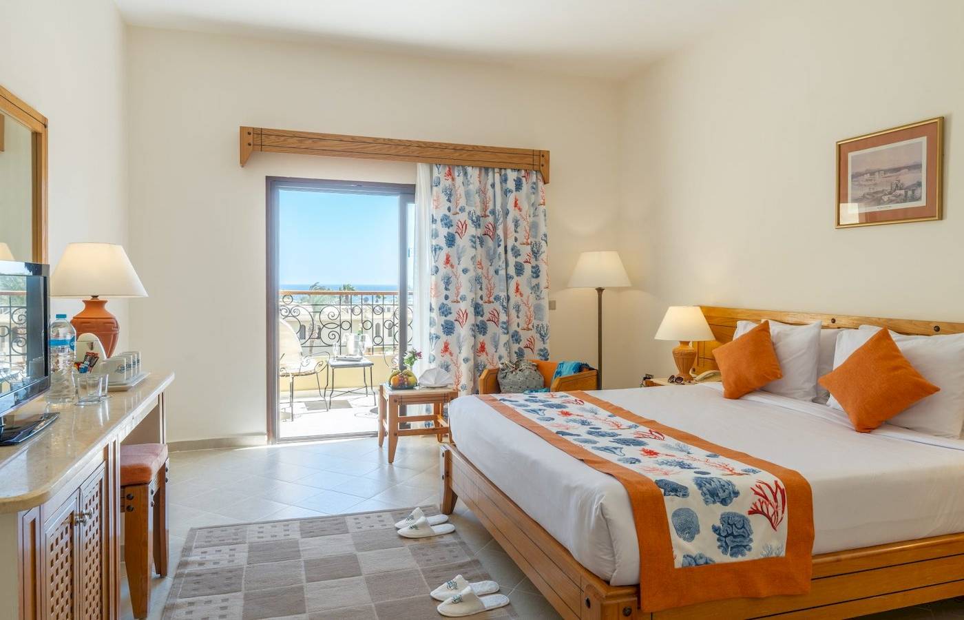 Ein elegantes Zimmer im Three Corners Fayrouz Plaza Beach Resort mit einem großen Bett und einem Balkon mit Meerblick.