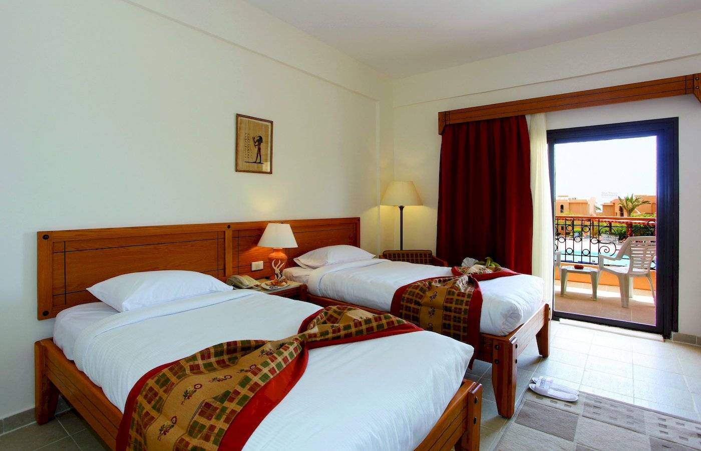 Zwei Betten im Zimmer im Three Corners Fayrouz Plaza Beach Resort mit Blick auf den Balkon.