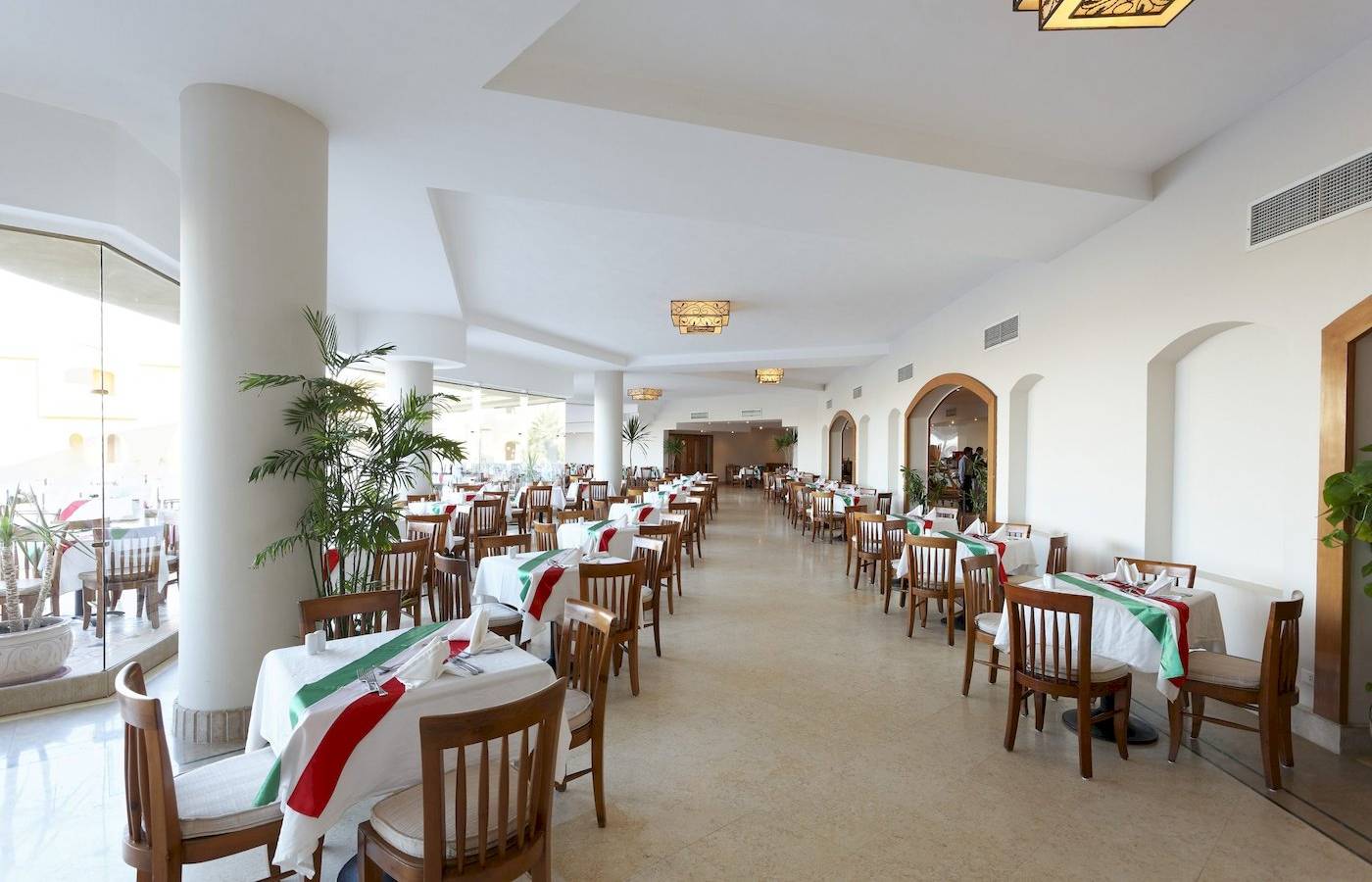 Innenbereich des Restaurants im Three Corners Fayrouz Plaza Beach Resort mit gedeckten Tischen und Stühlen