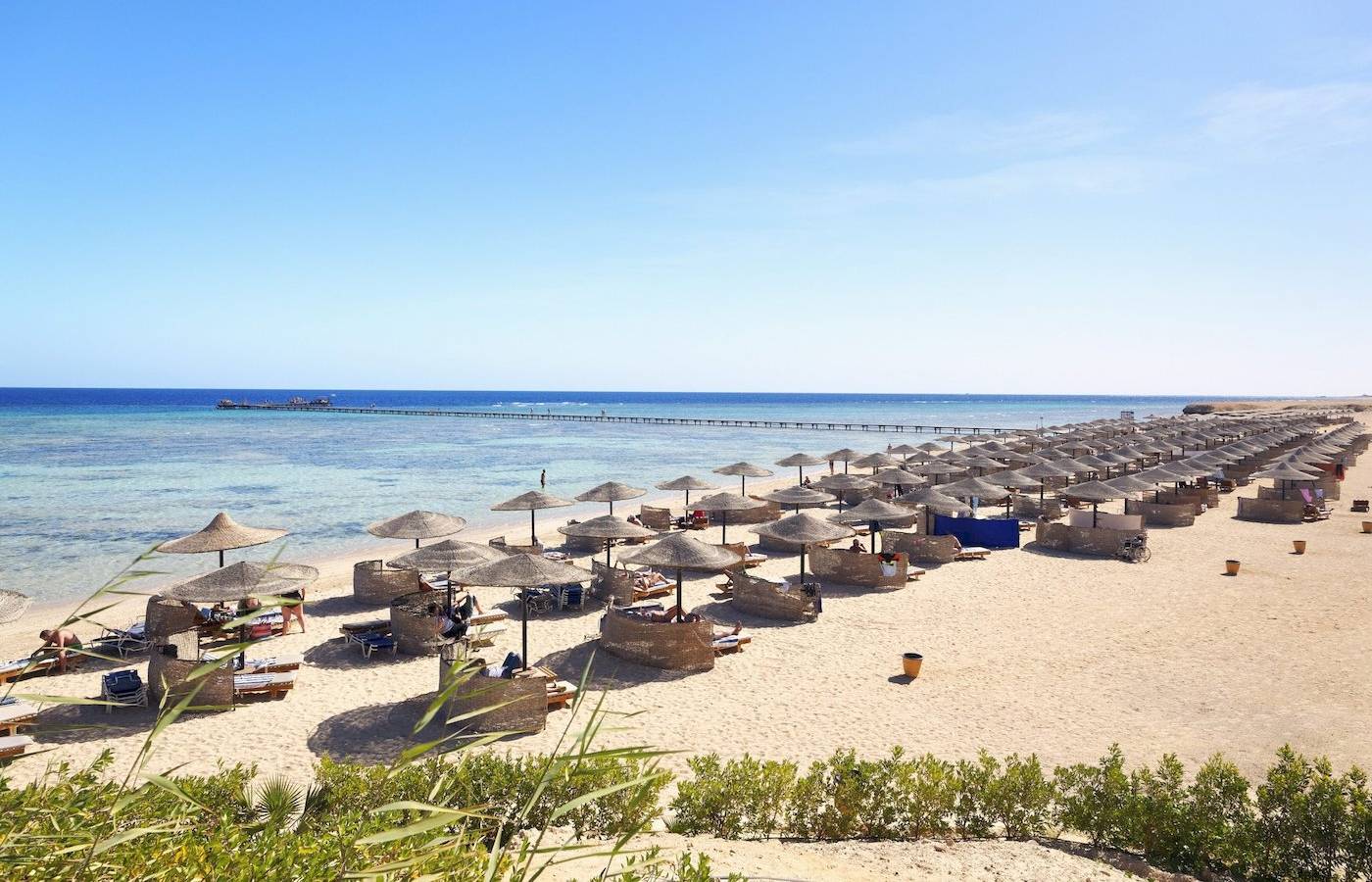 Drei-Ecken-Fayrouz-Plaza-Strandresort mit vielen Liegen und Sonnenschirmen am Strand