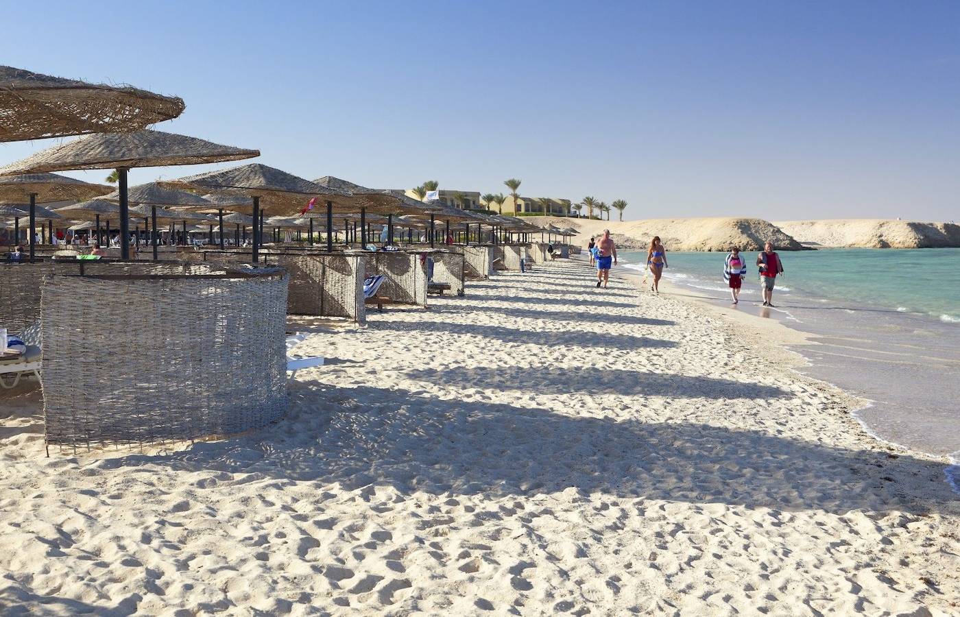 Strand mit Sonnenschirmen und Gästen im Three Corners Fayrouz Plaza Beach Resort.