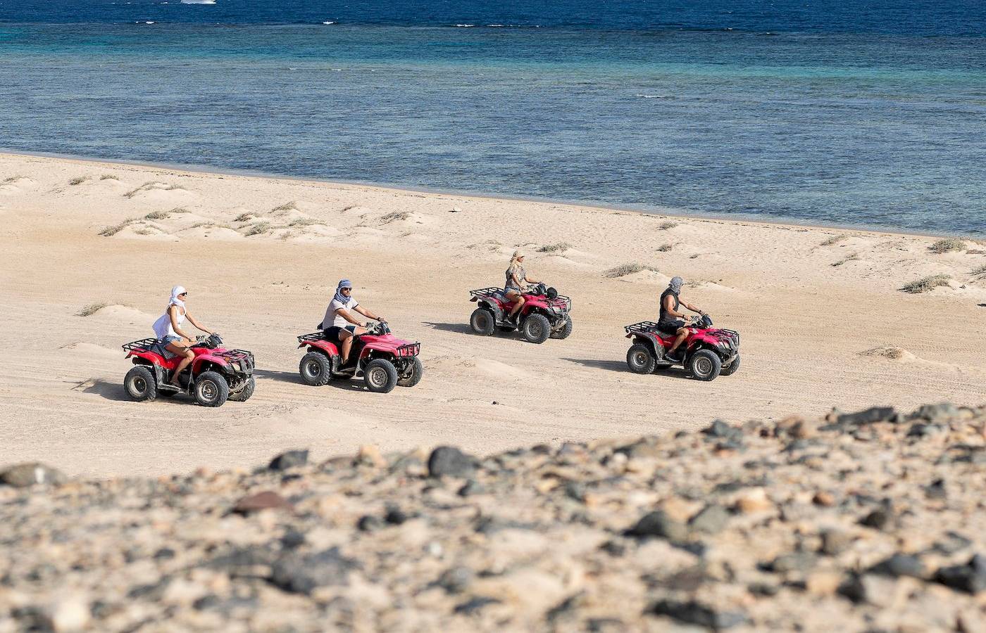 Vier Personen auf Quads am Strand des Three Corners Fayrouz Plaza Beach Resort.