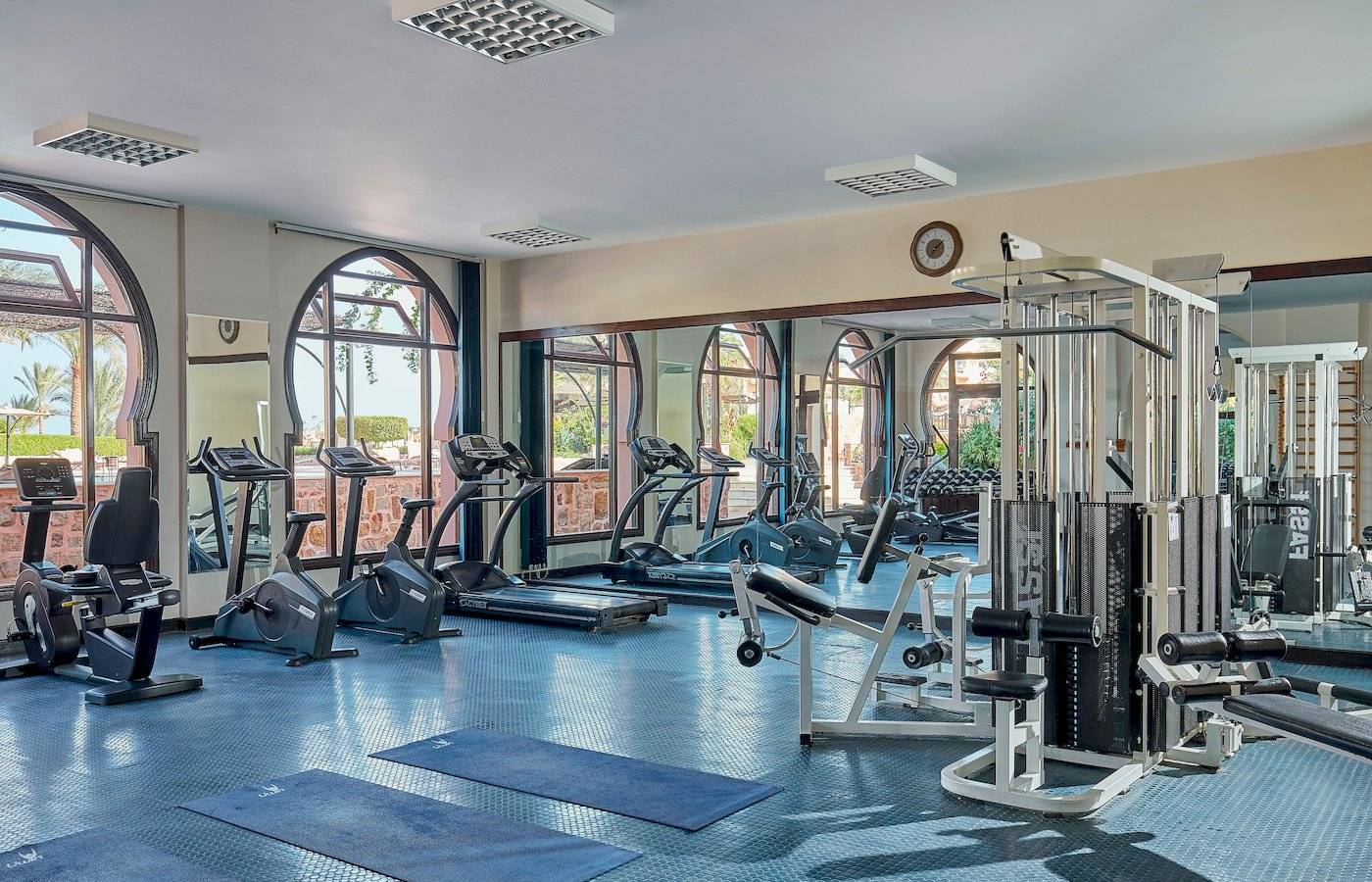 Fitnesscenter im Steigenberger Coraya Beach Hotel mit diversen Trainingsgeräten und großen Fenstern.