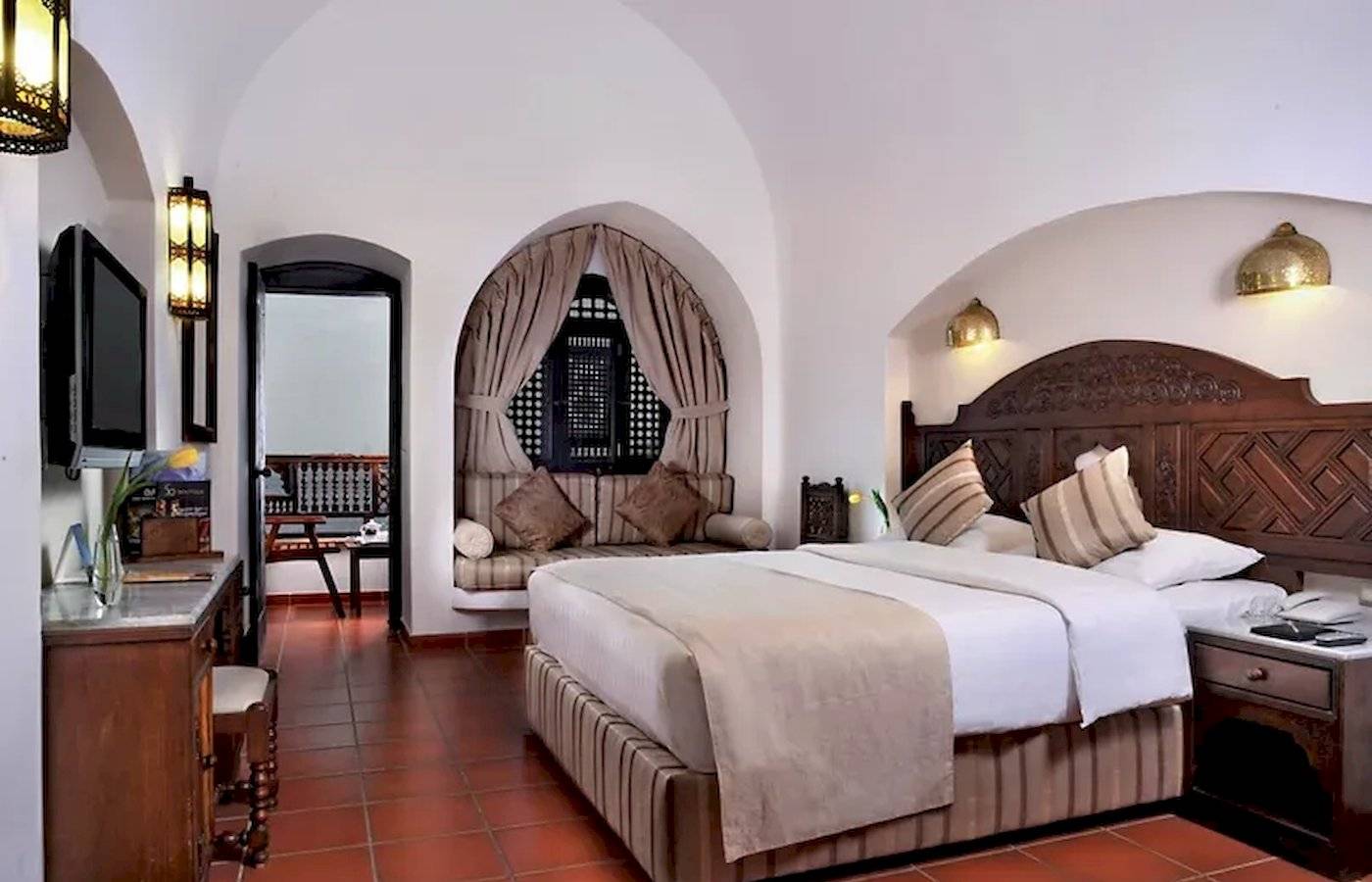 Zimmer im Mövenpick Resort Sharm el Sheikh mit großem Bett, Sofa und Fernseher