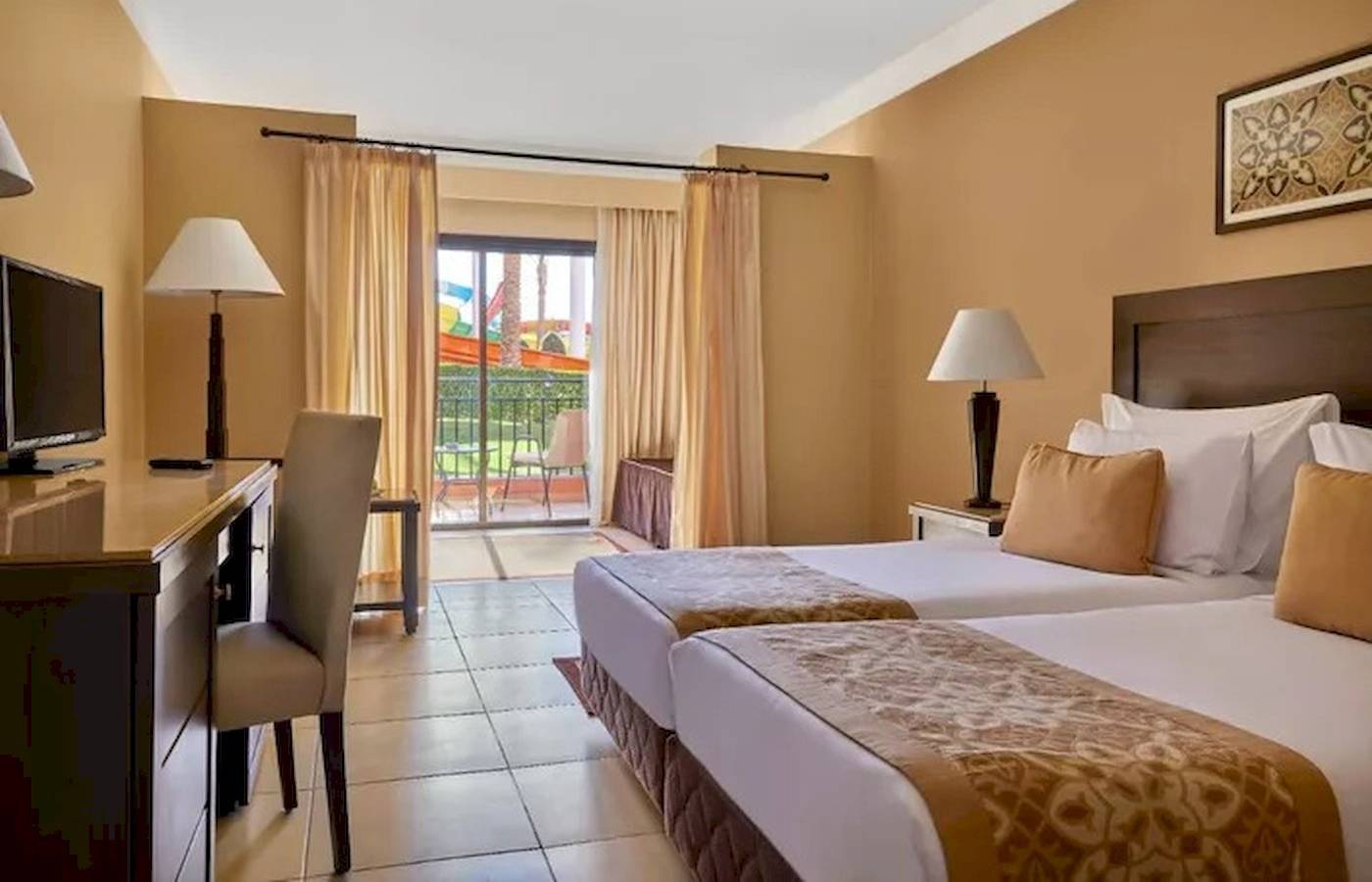 Hotelzimmer im JAZ Neo Dar El Madina mit zwei Betten, Schreibtisch und Balkon