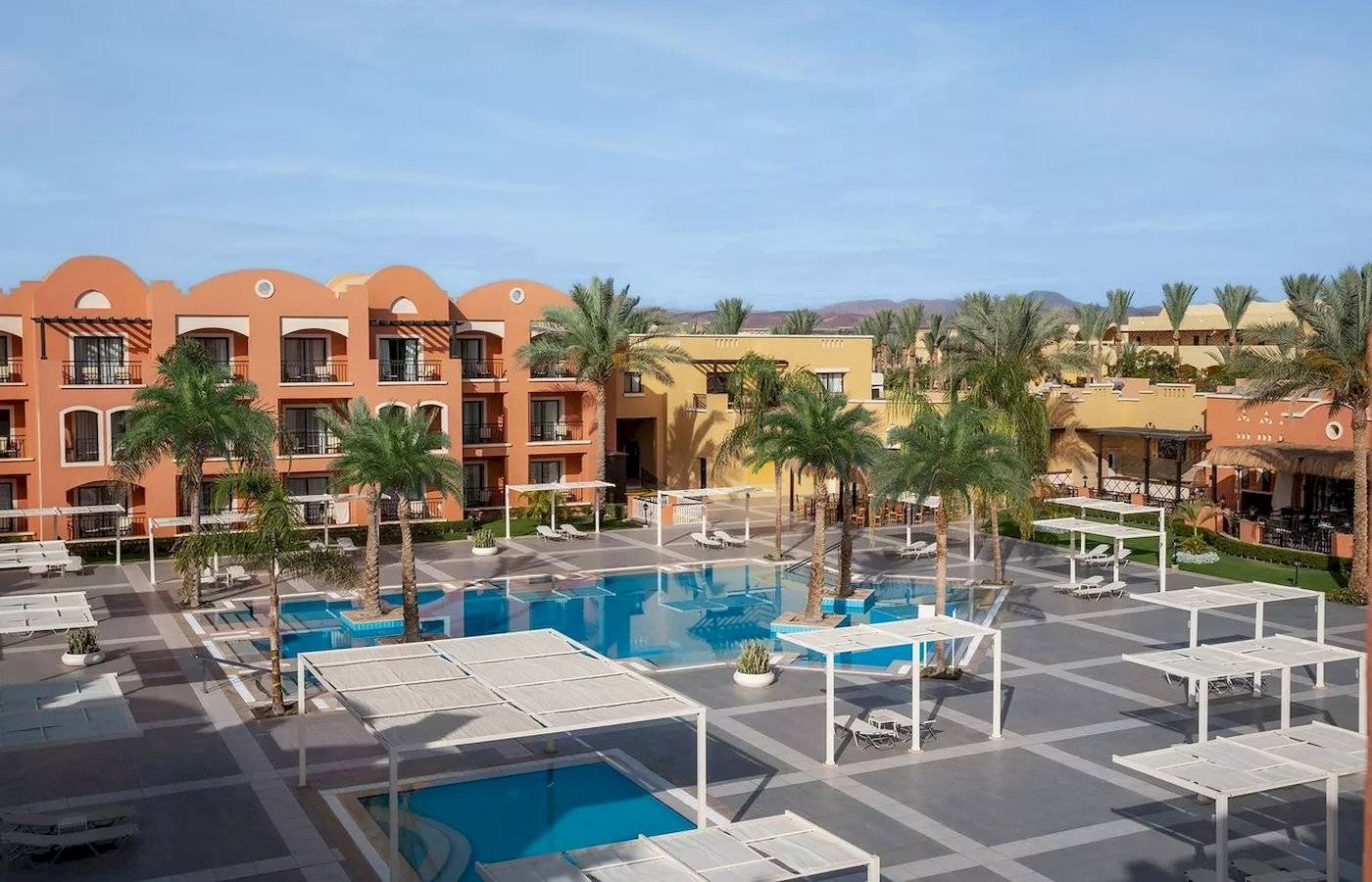 Außenansicht des Jaz Neo Dar El Madina Hotels mit Swimmingpool und Sonnenliegen