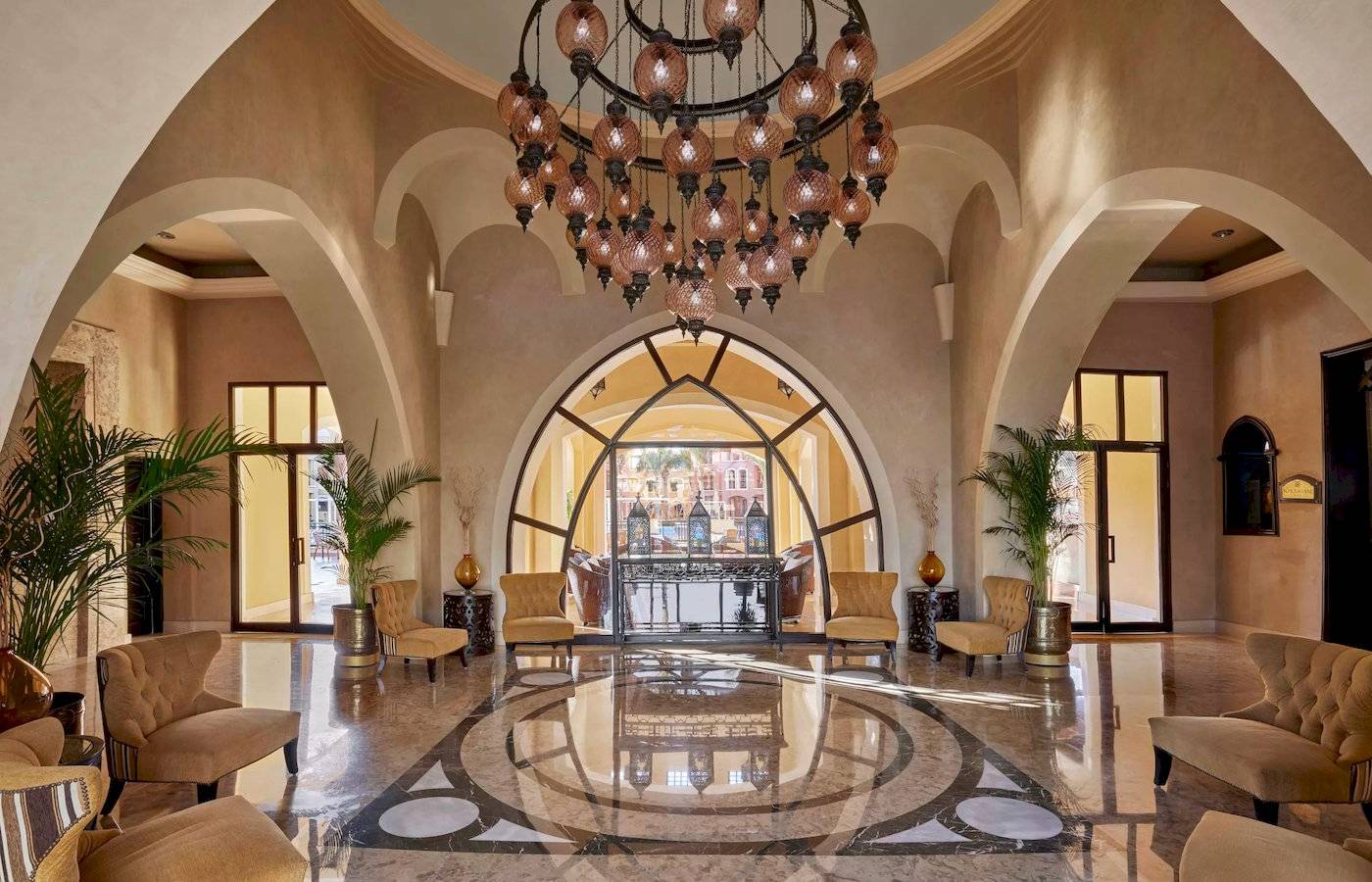 Hotellobby des JAZ Neo Dar El Madina mit einem großen Kronleuchter und Möbeln