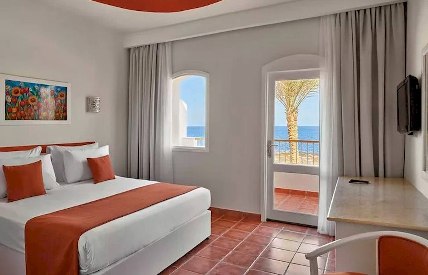 Hotelzimmer mit Bett und Balkon mit Meerblick im JAZ Neo Reef Marsa