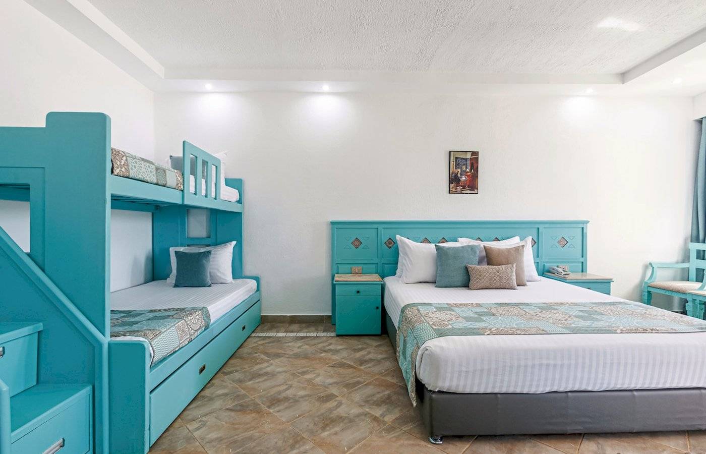 Zwei-Bettzimmer im Sunrise Royal Makadi Resort mit blauen Möbeln und einer Treppe.