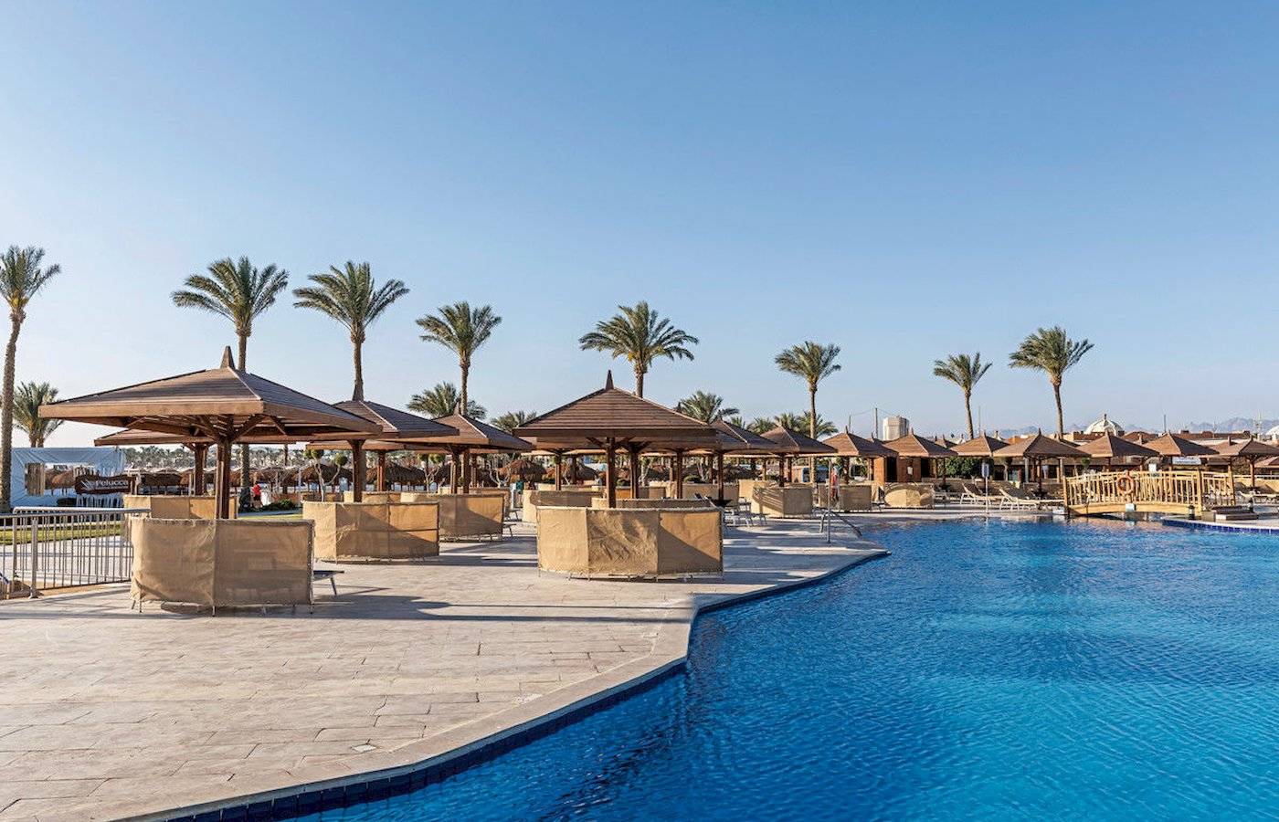 Poolbereich des Sunrise Royal Makadi Resorts mit Palmen und Sonnenschirmen