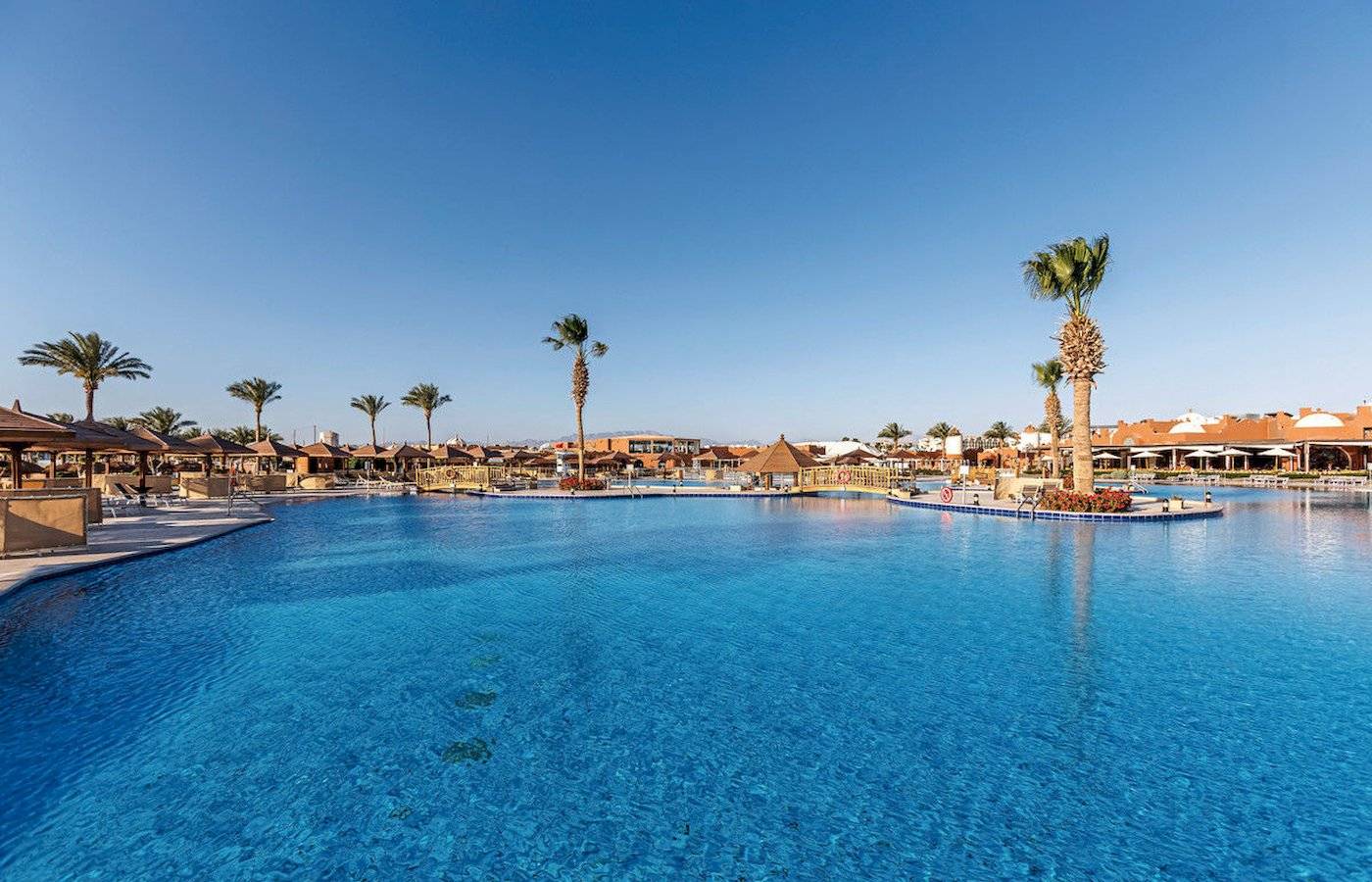 Außenpool im Sunrise Royal Makadi Resort mit Palmen und Sonnenschirmen