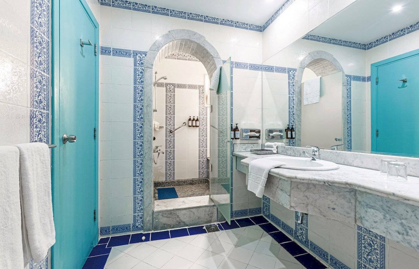 Badezimmer im Sunrise Royal Makadi Resort mit blauen Fliesen und weißen Marmor.