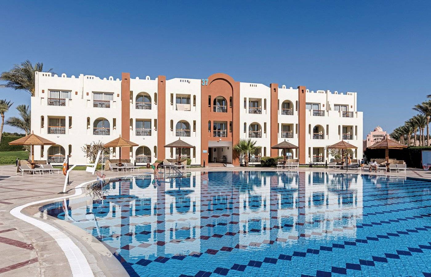 Außenbereich des Sunrise Royal Makadi Resort mit Swimmingpool und Hotelgebäude