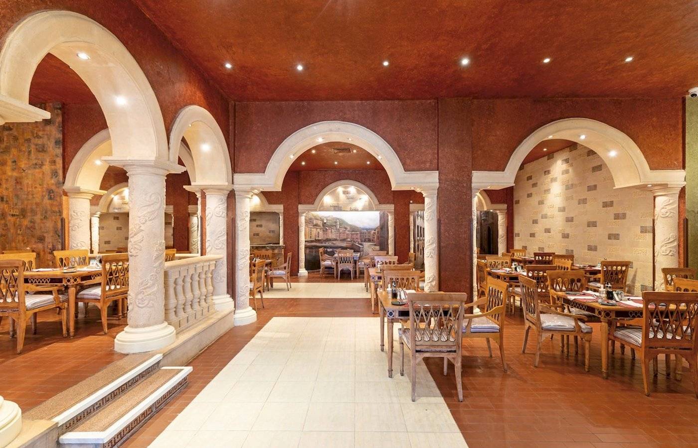 Restaurant im Sunrise Royal Makadi Resort mit Holztischen und Stühlen.
