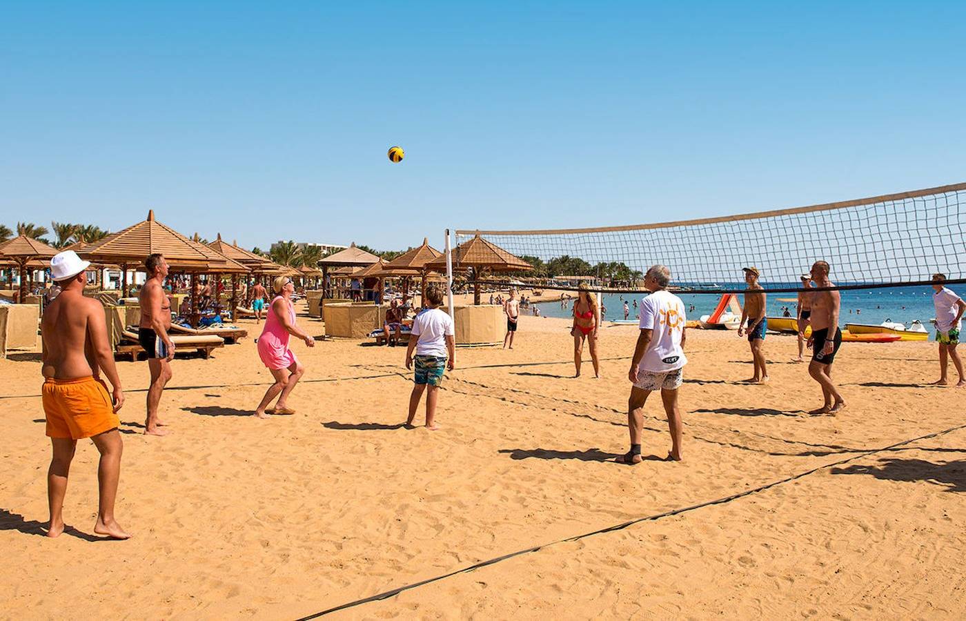 Beachvolleyball-Spiel am Sunrise Royal Makadi Resort mit Teilnehmern und einem Ball in der Luft.