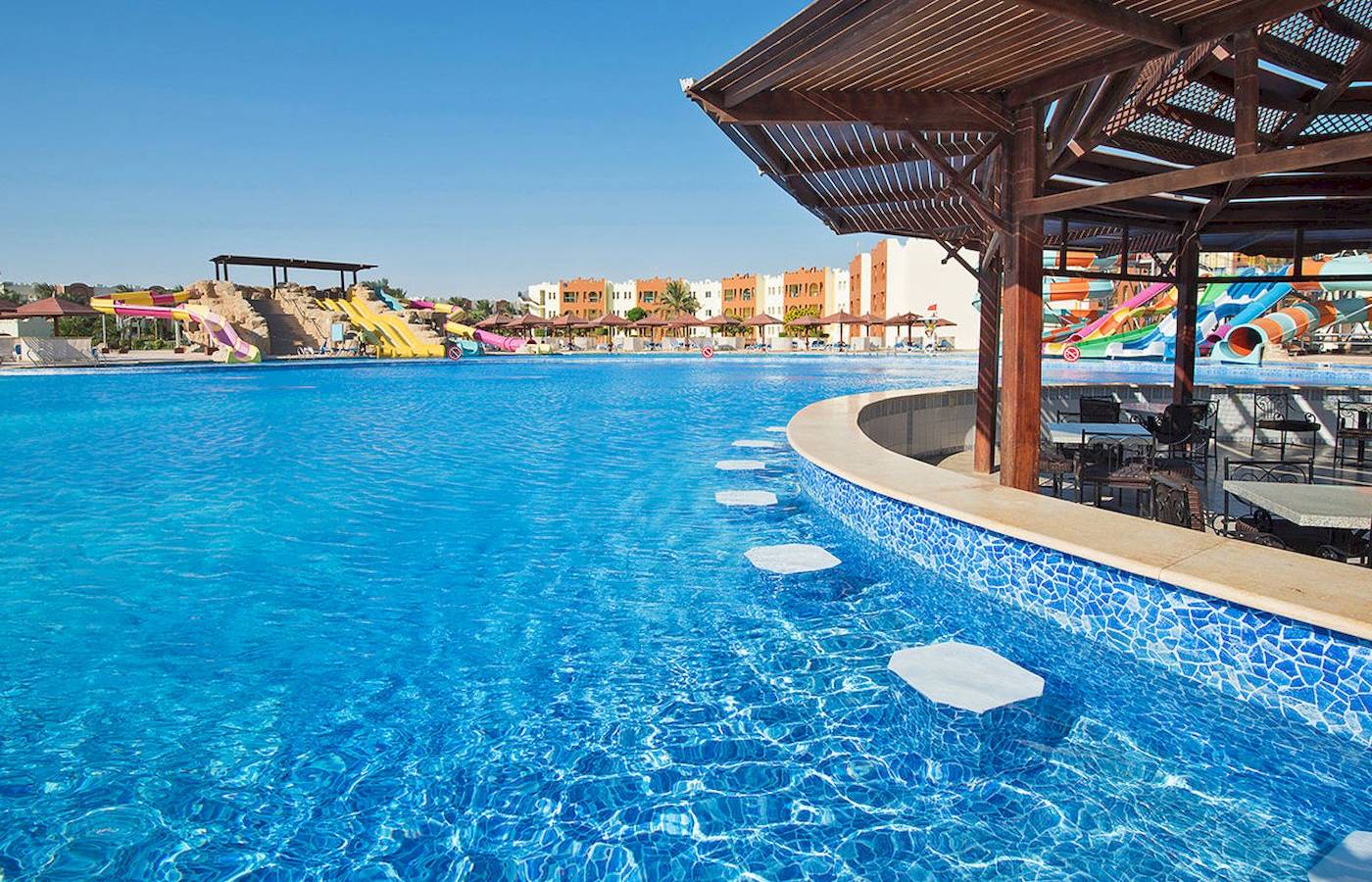 Außenpool des Sunrise Royal Makadi Resorts mit Wasserrutschen im Hintergrund.