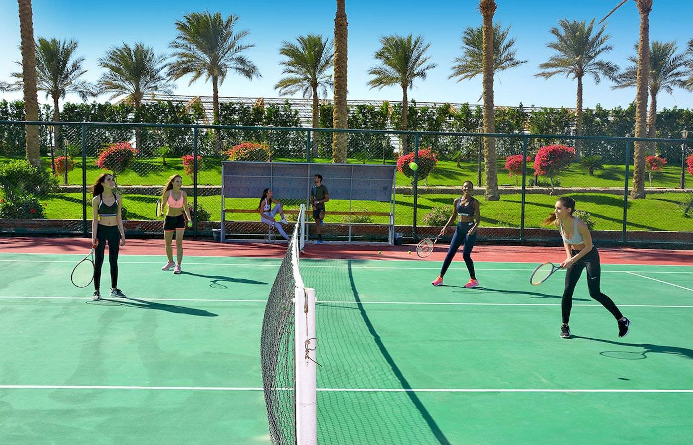 Tennisspiel im Sunrise Royal Makadi Resort mit Spielern und Zuschauern im Freien.