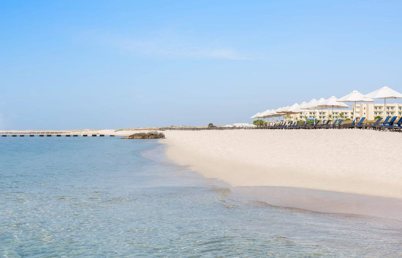 Wyndham Garden Salalah Mirbat Hotel Strand mit Sonnenschirmen und Liegen