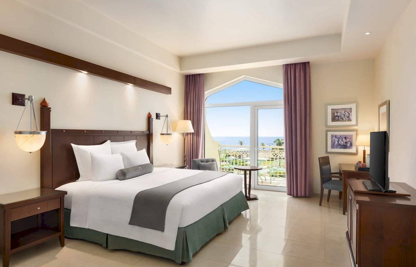 Wyndham Garden Salalah Mirbat Hotel Zimmer mit Kingsize-Bett und Meerblick.