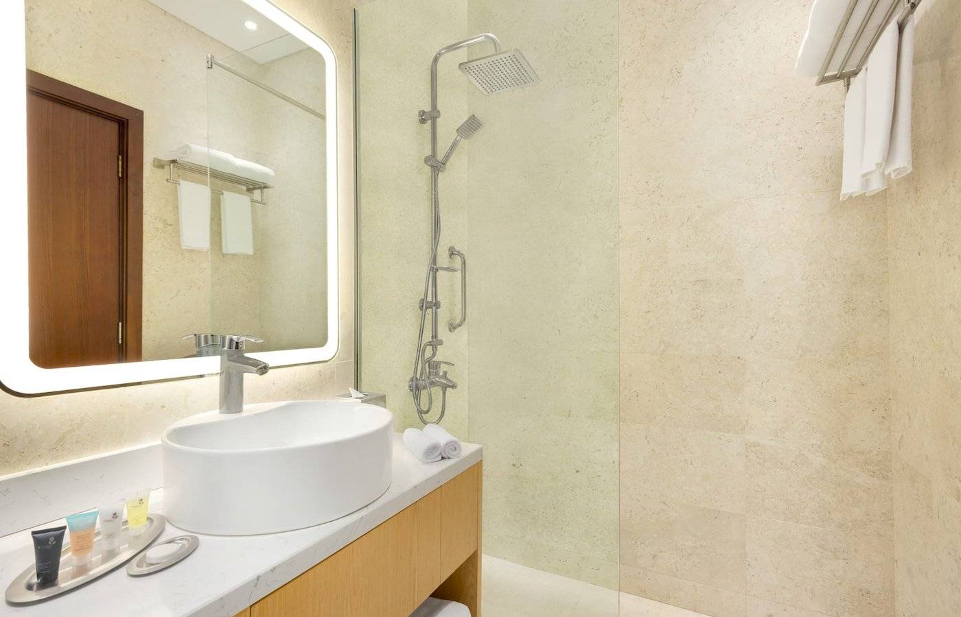 Badezimmer im Wyndham Garden Salalah Mirbat Hotel mit Waschbecken, Spiegel und Dusche