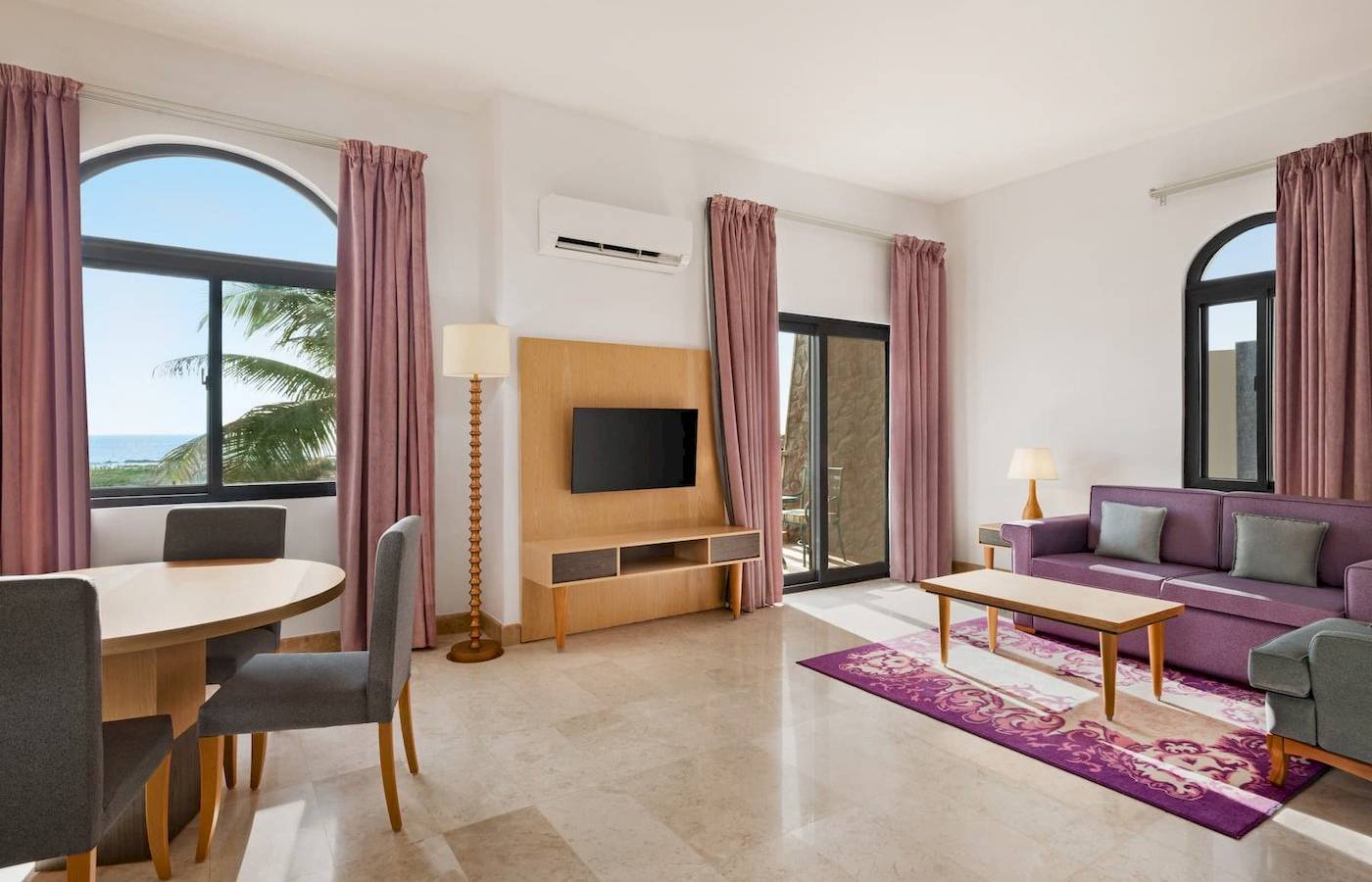 Wohnzimmer im Wyndham Garden Salalah Mirbat Hotel mit Möbeln, Fernseher und Meerblick