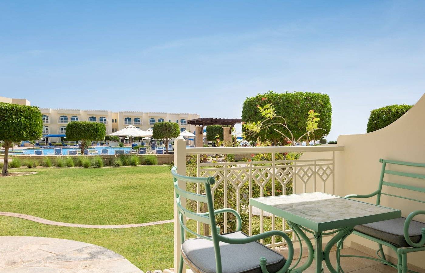 Blick vom Balkon des Wyndham Garden Salalah Mirbat Hotels auf den Swimmingpool und die Gärten.