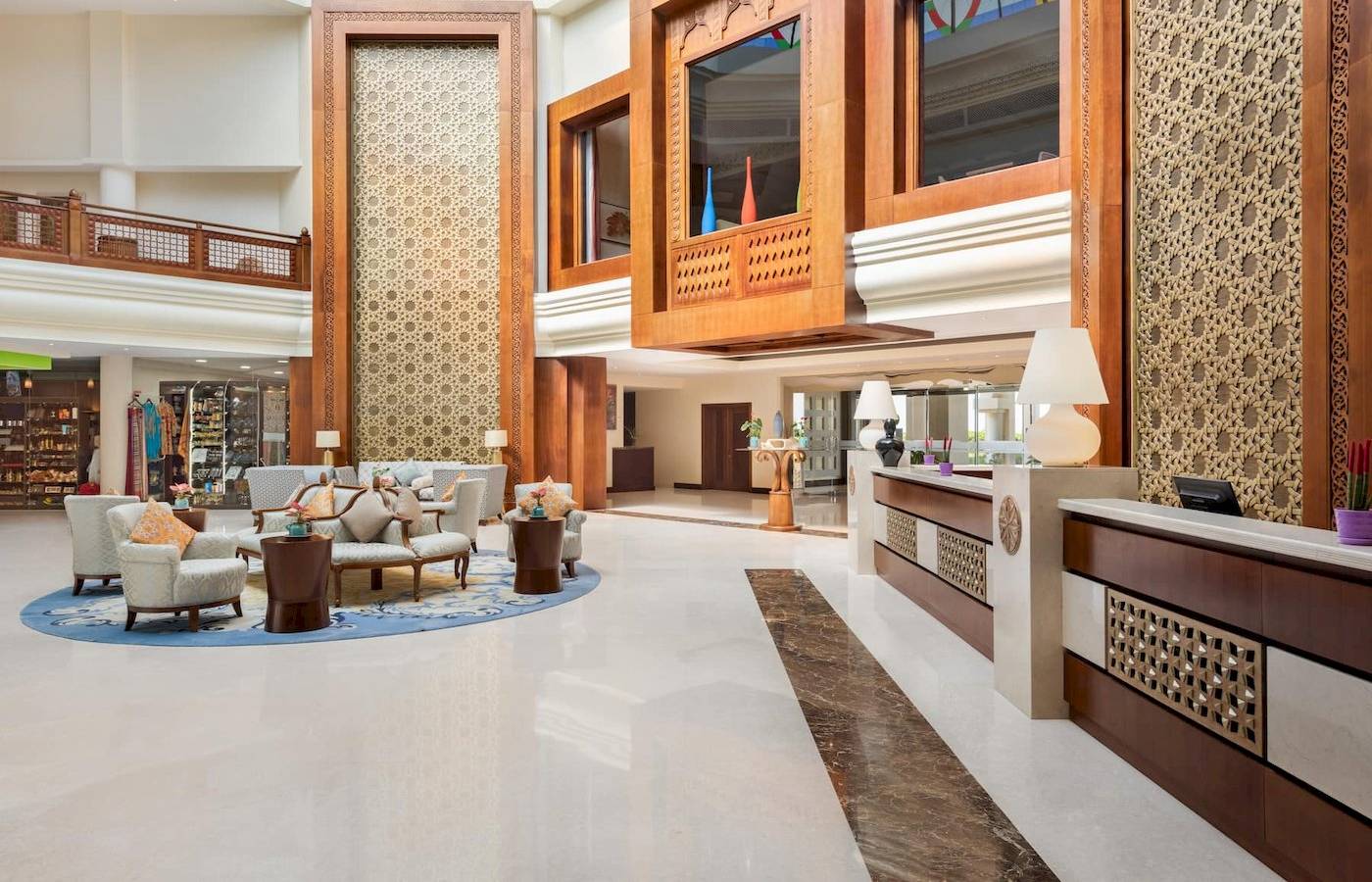 Empfangsbereich des Wyndham Garden Salalah Mirbat Hotels mit Loungemöbeln und Holzdekoration.