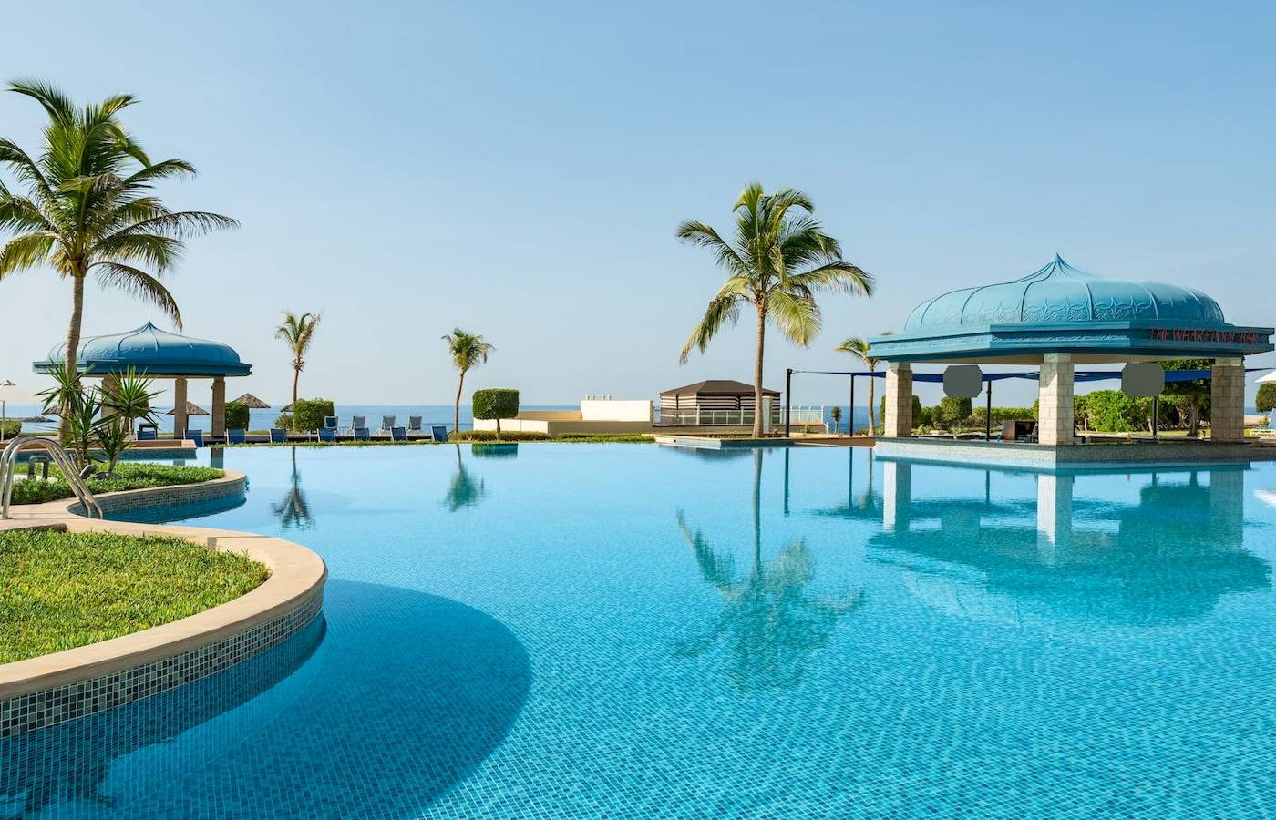 Außenpool des Wyndham Garden Salalah Mirbat Hotels mit Blick auf das Meer.