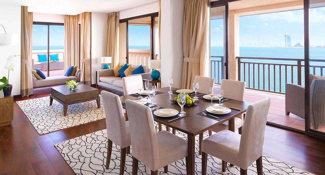 Wohnzimmer im Anantara The Palm Dubai Resort mit Blick auf das Meer und eine Insel.