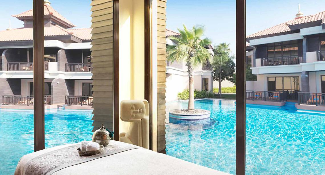 Ansicht von einem Zimmer im Anantara The Palm Dubai Resort mit Blick auf den Pool und Palme.