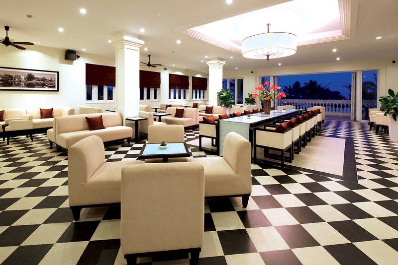 Lobby des Boutique Hoi An Resorts mit schachbrettartigem Boden und modernen Möbeln.