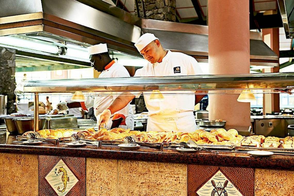 Küche im Buffetrestaurant des VOI Vila Do Farol Resorts mit zwei Köchen, die Speisen zubereiten