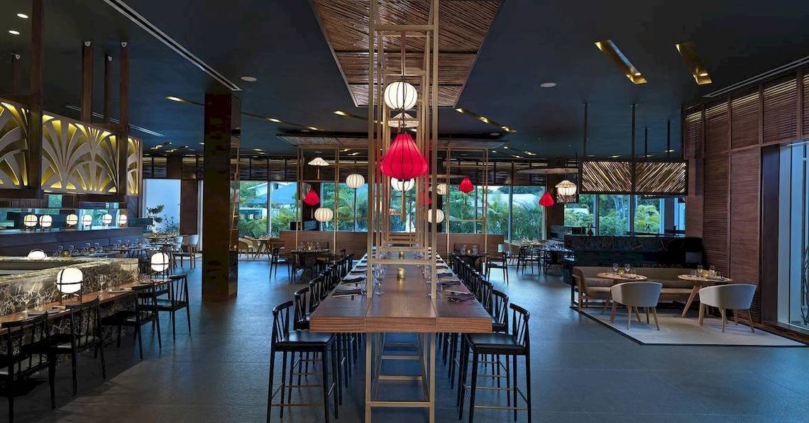 Restaurantbereich des Melia Caribe Beach Resorts mit langen Tischen, Stühlen und roten Laternen.