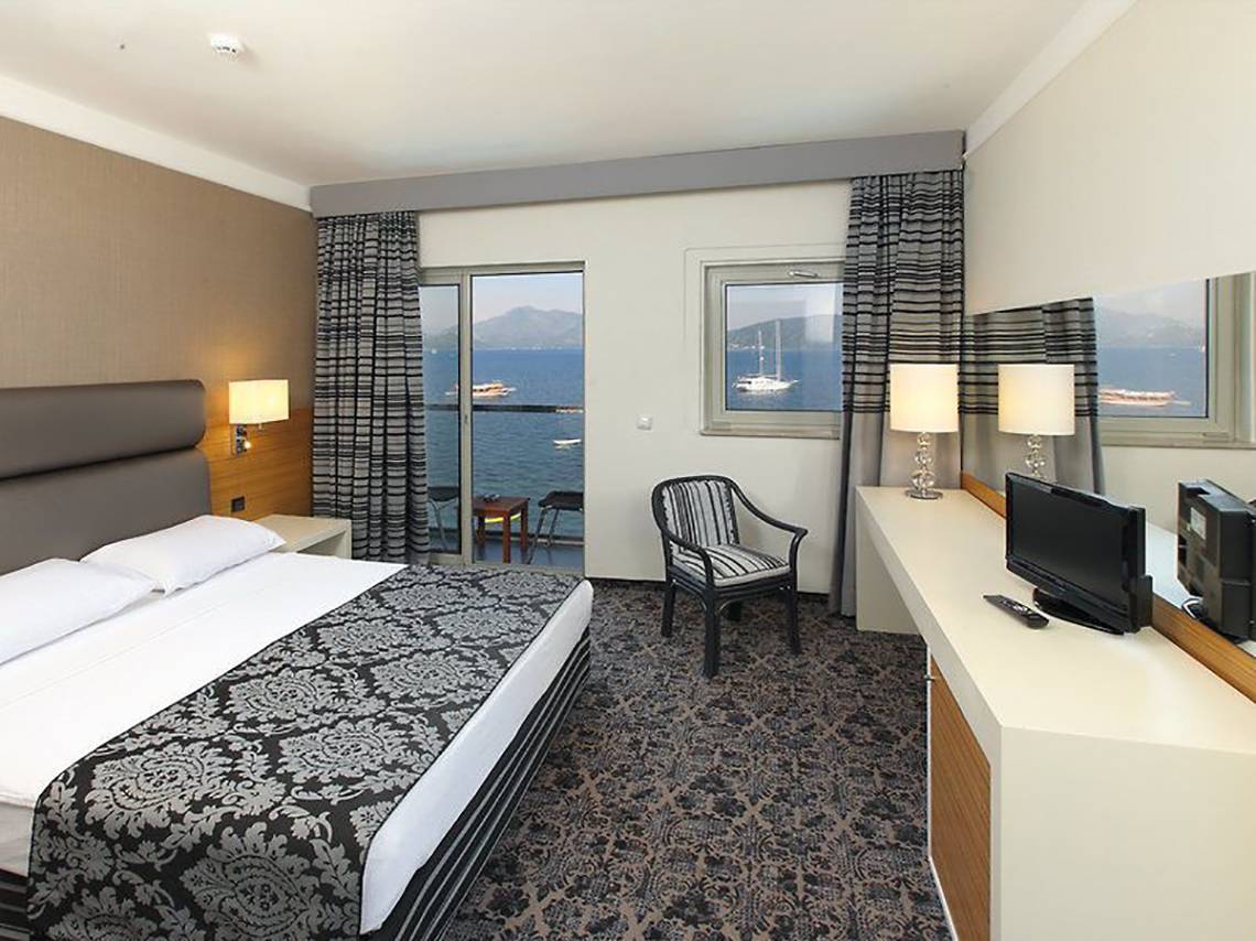 Bettzimmer im Cettia Beach Resort mit Meerblick, modernem Design und bequemen Möbeln.