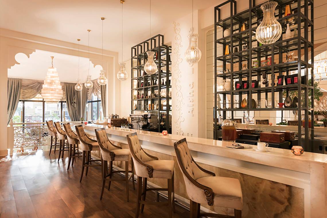 Hotelbar Bereich im Rixos Bab Al Bahr mit eleganten Stühlen und Theke.