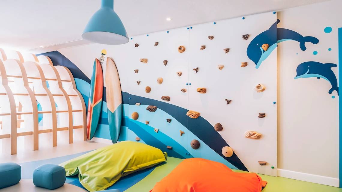 Hotelzimmer im Iberostar Waves Alcudia Park mit bunter Wandgestaltung und Kletterwand.