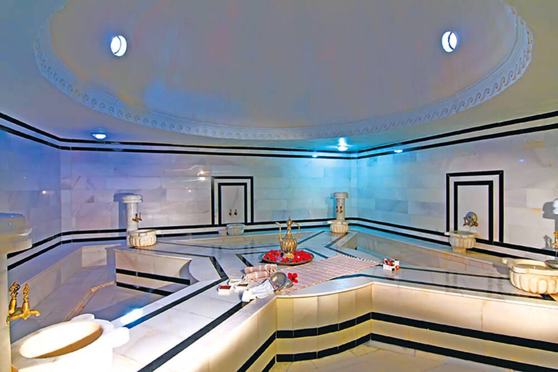 Innenansicht des Hamams im Club Nena Hotel mit weißen Marmorwänden und schwarzen Akzenten.