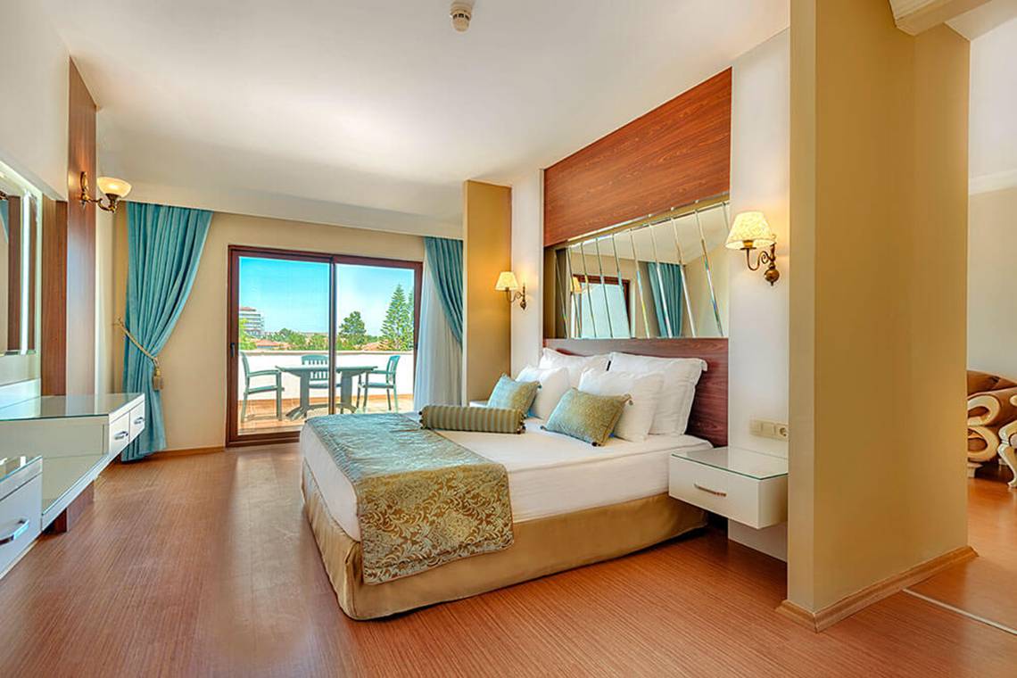 Club Nena Hotel Schlafzimmer mit Balkon und Panoramafenstern.