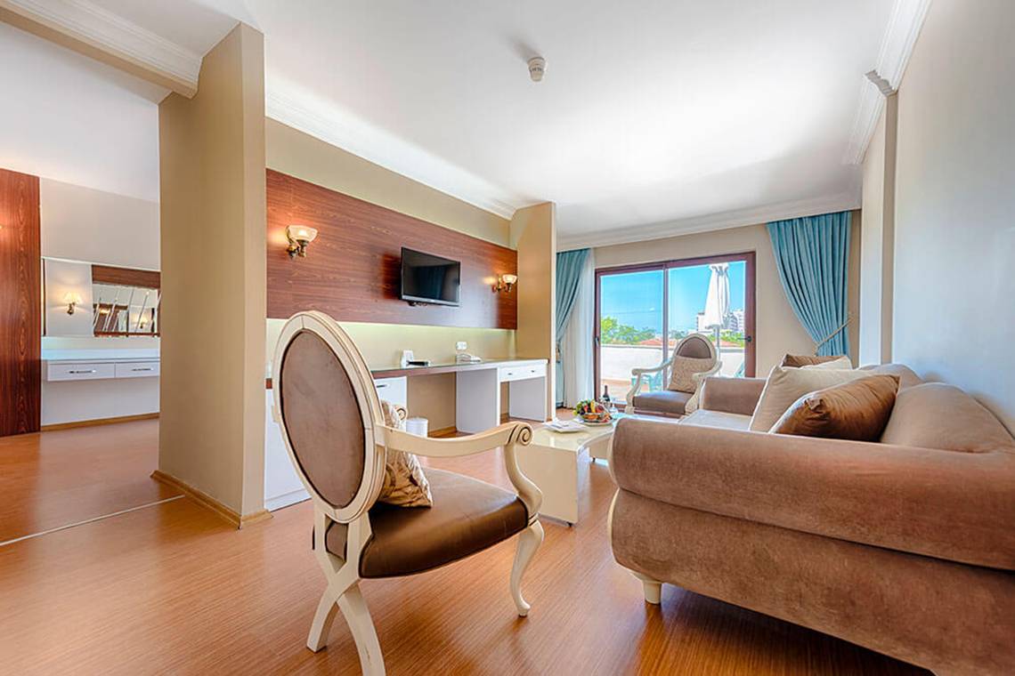 Wohnbereich des Club Nena Hotels mit Sofa, Tisch, Stuhl und Fernseher