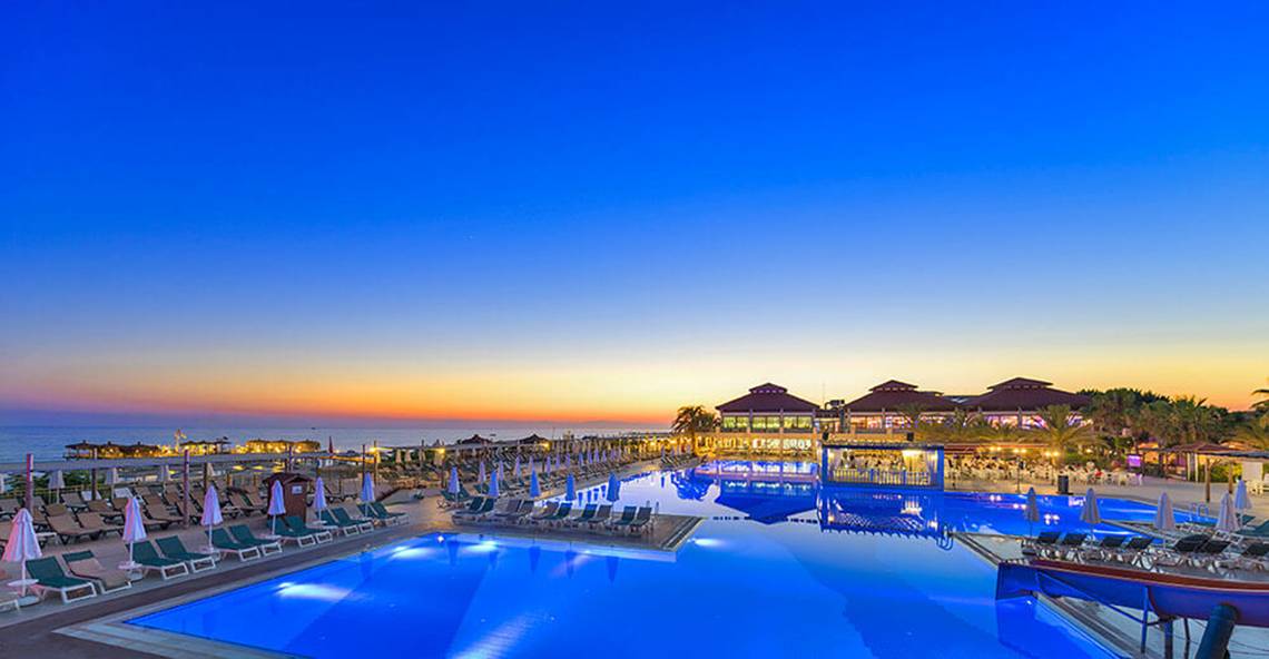 Abendlicher Swimmingpool im Club Nena Hotel mit Sonnenuntergang am Horizont