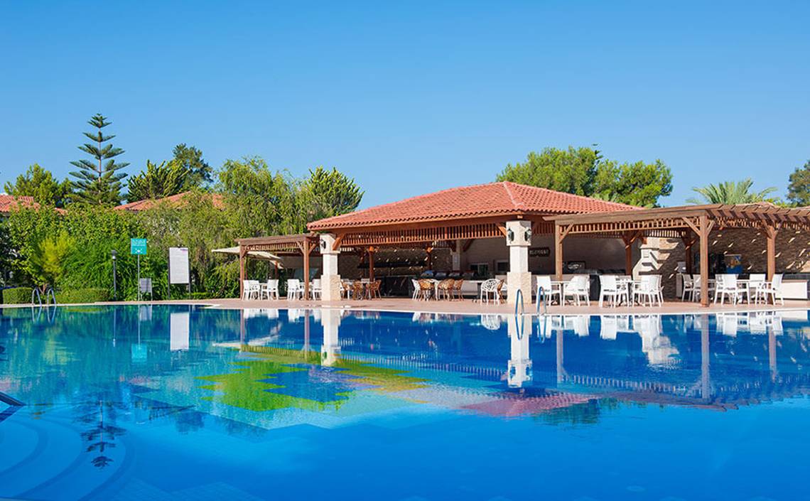 Außenpool des Club Nena Hotels mit umliegenden Bäumen und Sitzbereich.