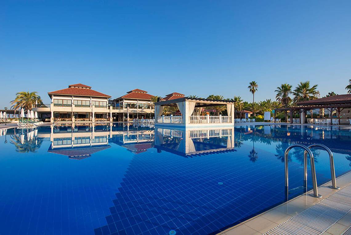 Ein blauer Swimmingpool mit einem großen Hotel im Hintergrund