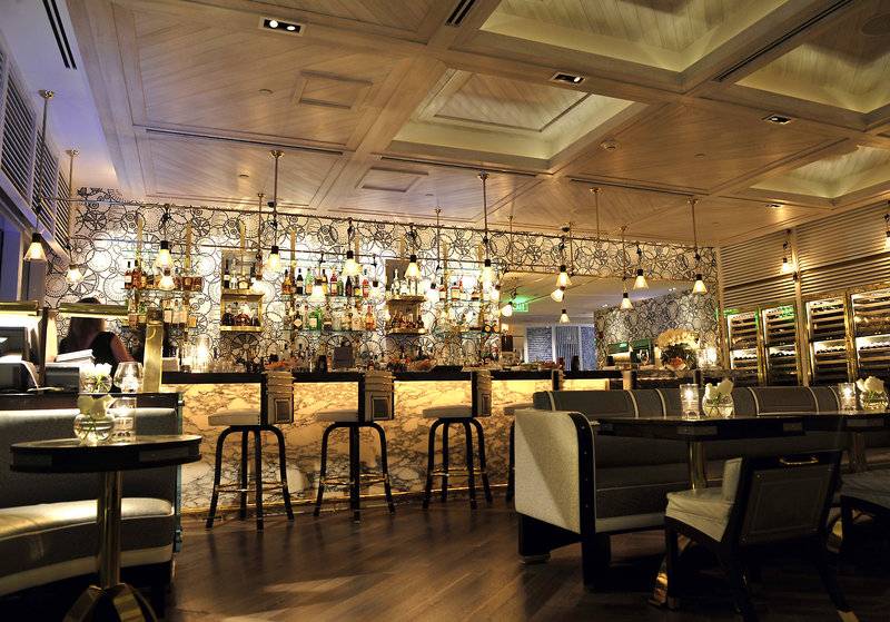 Innenansicht der Bar im Fontainebleau Miami Beach Hotel mit gemusterten Wänden und Holzboden.