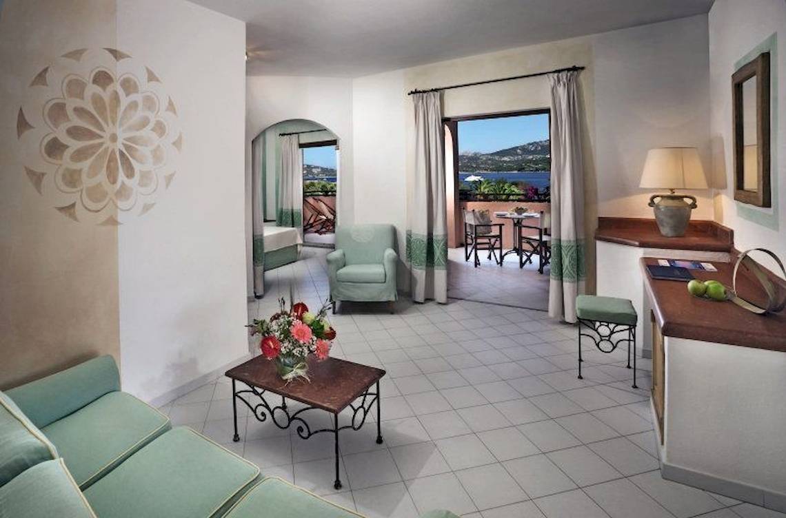Innenansicht der Suite im Resort Cala Di Falco mit Blick auf den Balkon und das Meer.
