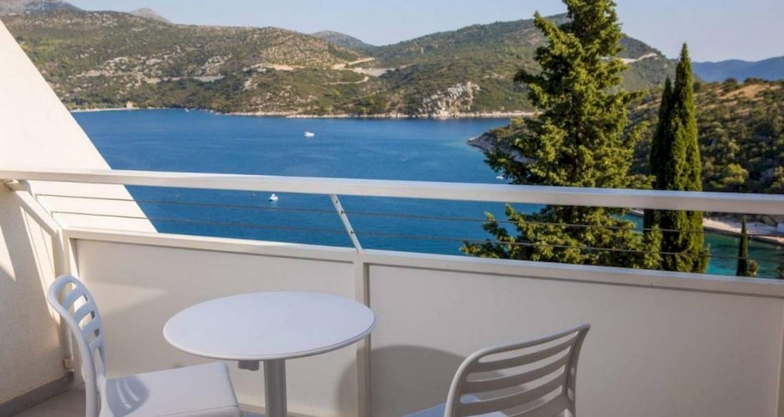 Balkon mit Meerblick im Osmine Slano Hotel mit zwei weißen Stühlen und einem Tisch.