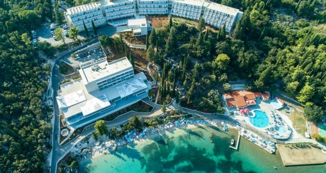 Luftaufnahme des Osmine Slano Hotels, umgeben von Bäumen und mit Blick auf das Meer.